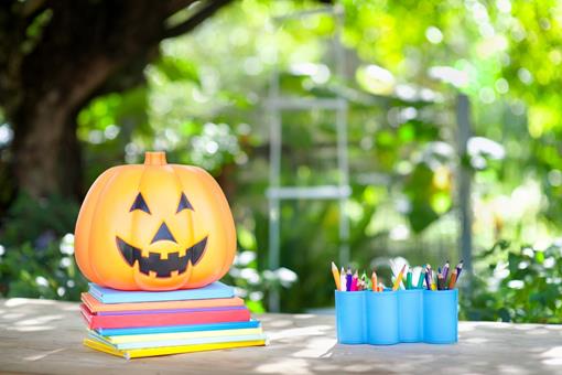 Pumpkin on notepads with pencils next to it
