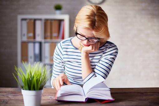 School leadership: Books for SBMs - woman reading a book in her office