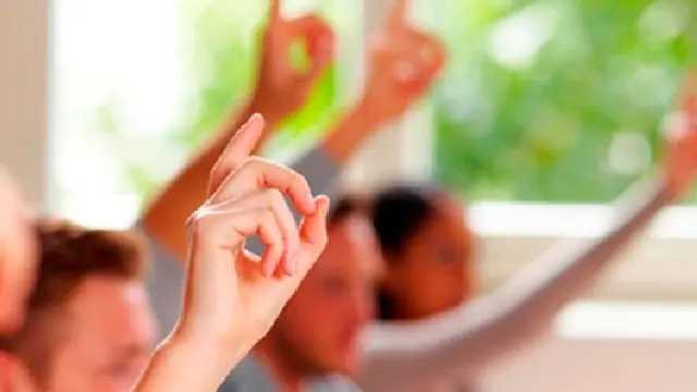 Students raising their hands to ask a question