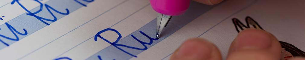 Primary school children learning handwriting with specialized pens in a classroom environment
